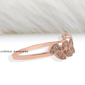 May include: A rose gold ring with a delicate leaf design set with small diamonds.