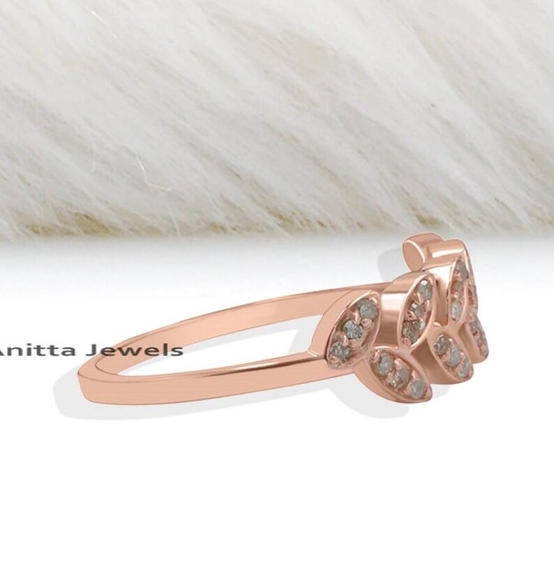 May include: A rose gold ring with a delicate leaf design set with small diamonds.