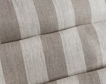 May include: Close-up of a folded fabric with a striped pattern in shades of brown and white. The fabric has a textured, linen-like appearance.