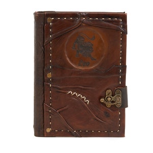 May include: Brown leather journal with a stitched border and a brass clasp. The front cover features an embossed lion with the word "Leo" underneath.