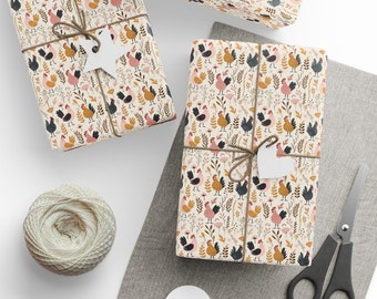 May include: Two gift boxes wrapped in white paper with a repeating pattern of colorful chickens, flowers, and leaves. The boxes are tied with twine and have white paper tags attached.