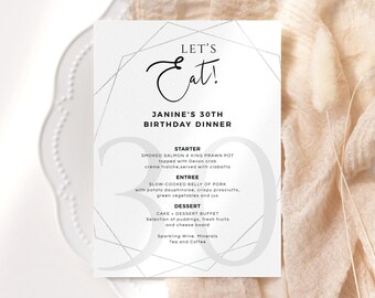 May include: A white menu card with a silver geometric design. The text on the card reads "Let's Eat! Janine's 30th Birthday Dinner". The menu includes a starter, entree, and dessert.