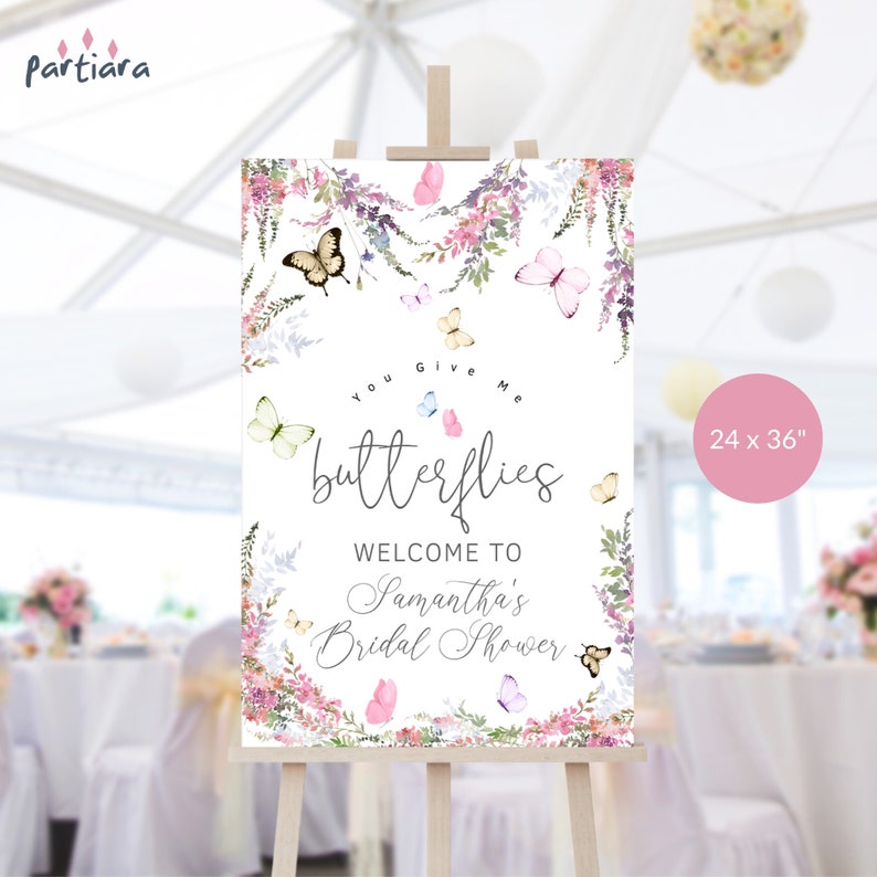 May include: A white welcome sign with a floral border and butterflies. The sign says "You Give Me Butterflies" and "Welcome to Samantha's Bridal Shower". The sign is 24 inches by 36 inches.