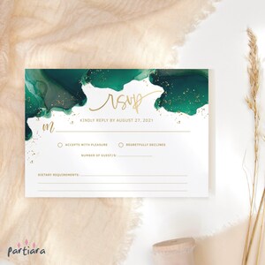 Op de afbeelding: Witte RSVP-kaart met een smaragdgroen aquarelontwerp en gouden accenten. De kaart bevat het woord "RSVP" in gouden script, samen met velden voor gastinformatie en een antwoorddatum.