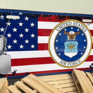 May include: A blue and red American flag with a distressed look. The flag has a white star field and red and white stripes. The flag has the United States Air Force seal in the centre. The seal is blue with a white eagle and the words "United States Air Force".