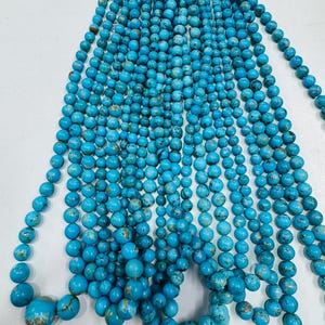May include: Strands of turquoise beads in various sizes, ranging from small to large. The beads are a vibrant blue-green color with natural brown matrix patterns. The beads are strung together, ready for jewelry making.