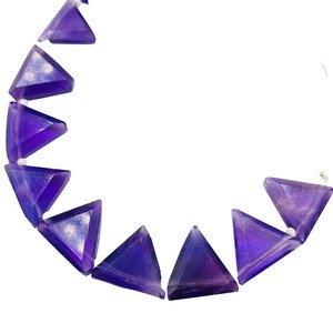 May include: A strand of purple amethyst triangle beads. The beads are faceted and have a shiny, iridescent finish.