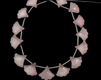 May include: A strand of pink rose quartz beads, each carved in the shape of a fan, strung on a silver wire.