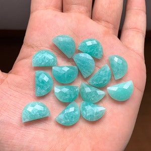 Pode incluir: Uma coleção de 14 cabochões de meia lua de pedra preciosa verde. Os cabochões são facetados e têm um acabamento liso e polido.