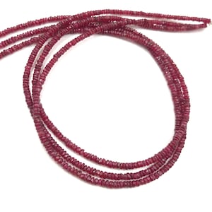Pode incluir: Um fio de contas de rubi vermelho escuro, com aproximadamente 45 cm de comprimento, com um formato facetado ligeiramente irregular. As contas são enfiadas em um fio transparente e estão prontas para a fabricação de joias.