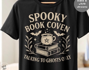 May include: Black t-shirt with a beige graphic design featuring the text "SPOOKY BOOK COVEN TALKING TO GHOSTS ONLY". The design includes bats, a cauldron, books, and botanical elements. The shirt is a digital download, available in black and white versions.