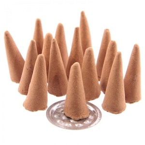 May include: A group of brown incense cones arranged on a white surface. The cones are stacked in a pyramid shape, with the largest cone at the bottom and the smallest cone at the top.