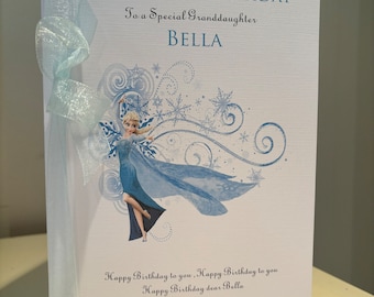 Puede incluir: Tarjeta de cumpleaños azul claro con el texto "HAPPY 5TH BIRTHDAY To a Special Granddaughter BELLA". La tarjeta presenta una ilustración de un personaje con un vestido azul y una cinta azul claro.