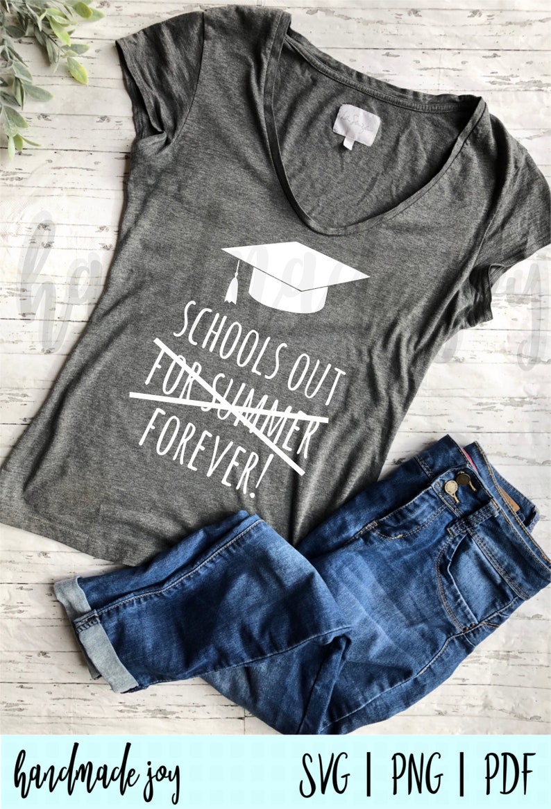 May include: Gray t-shirt with a white graduation cap and the text "Schools Out For Summer Forever!" printed on it. The shirt is laying on a wooden surface with a pair of blue jeans.
