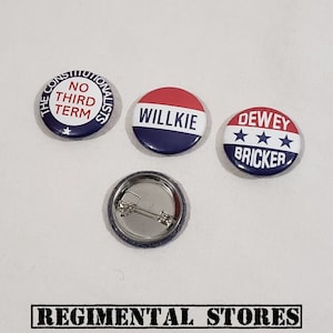 May include: Three vintage political campaign buttons. The first button is blue and white with the text "The Constitutionalists No Third Term". The second button is red, white, and blue with the text "Willkie". The third button is red, white, and blue with the text "Dewey Bricker" and three stars.