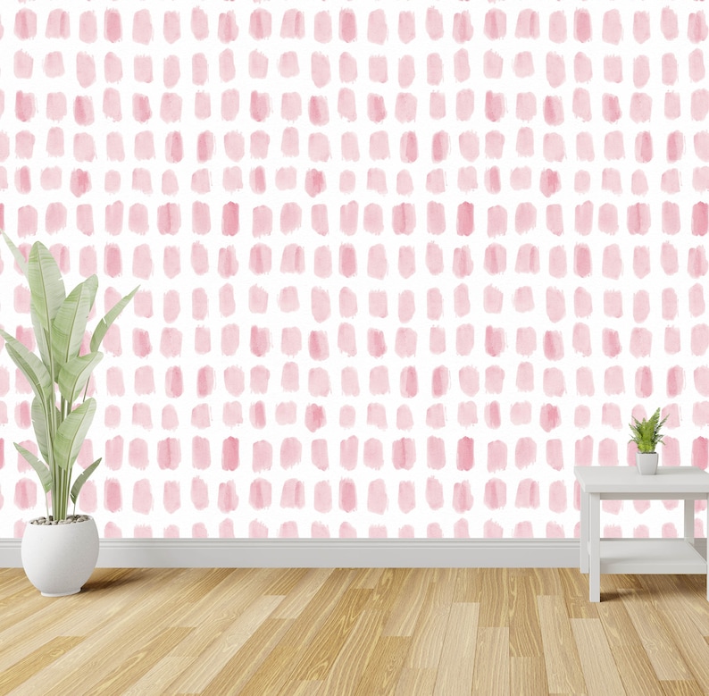 Puede incluir: Una pared blanca con un patr&oacute;n de puntos de acuarela rosa. Una planta en maceta y una peque&ntilde;a mesa blanca est&aacute;n en primer plano.