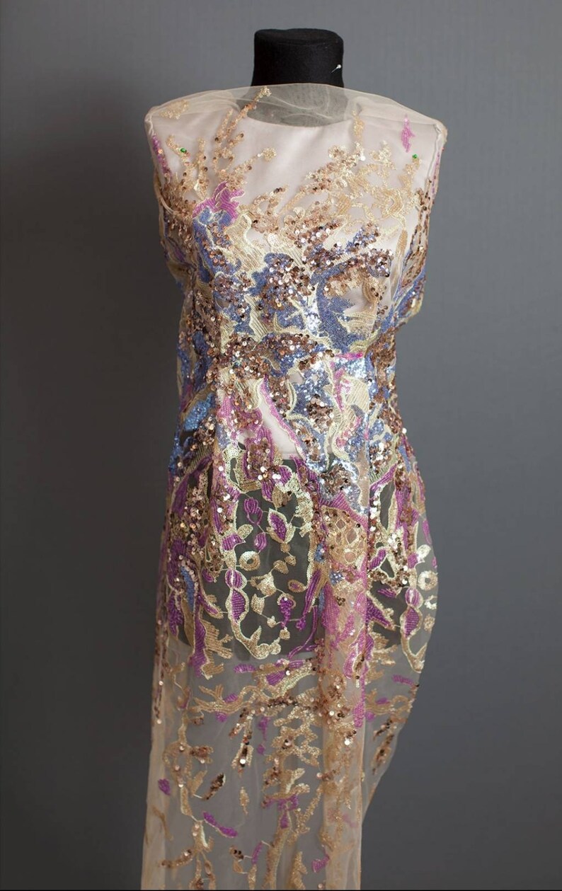 May include: A sheer fabric with a floral pattern embroidered with gold, pink, and blue sequins.