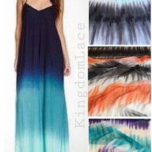 May include: A maxi dress with a gradient pattern in shades of blue, teal, and green. The dress has a halter neckline and a loose, flowing silhouette. The fabric is sheer and lightweight.