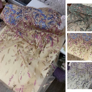 May include: A close-up of three different colors of sequined fabric. The fabric is a sheer mesh with sequins in a variety of colors, including gold, pink, blue, and green. The fabric is perfect for making dresses, skirts, tops, and other garments.