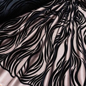 May include: Black velvet fabric with a wavy, abstract pattern on a light pink background.