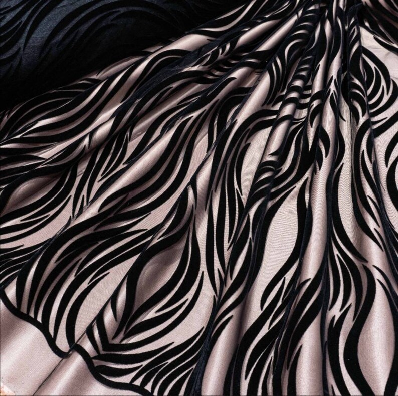 May include: Black velvet fabric with a wavy, abstract pattern on a light pink background.