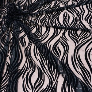 May include: Black sheer fabric with a wavy, abstract pattern in black velvet. The fabric is draped and shows the texture of the velvet.