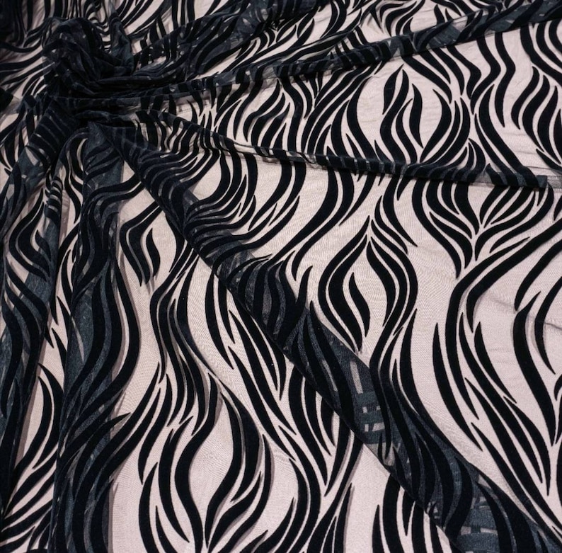 May include: Black sheer fabric with a wavy, abstract pattern in black velvet. The fabric is draped and shows the texture of the velvet.