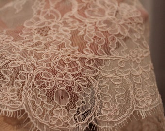 May include: Close-up of delicate white lace fabric with a floral pattern.