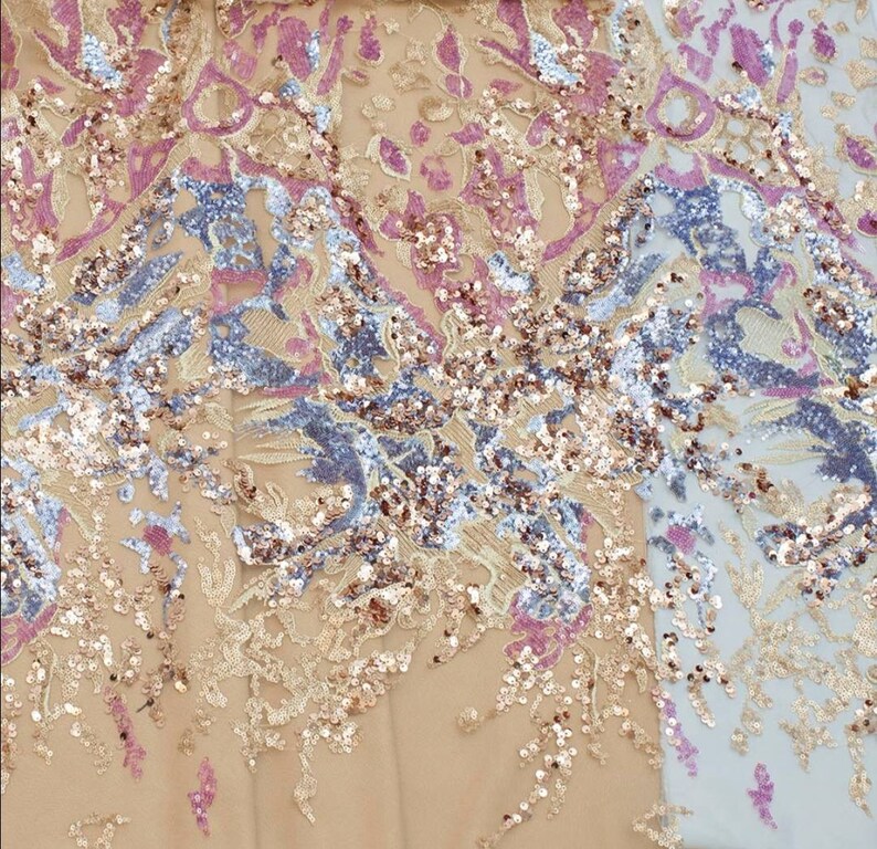 May include: A close-up of a fabric with a floral pattern and sequins in shades of pink, gold, and blue.