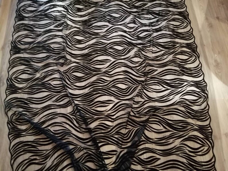 May include: Black and white wavy patterned fabric. The fabric has a sheer, mesh-like texture.