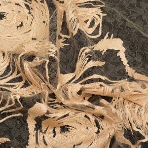 May include: Beige floral lace fabric with a delicate pattern of roses. The fabric is sheer and has a soft, flowing texture.
