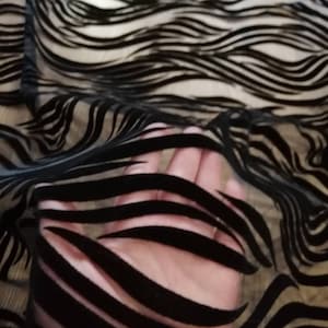 May include: Black sheer fabric with a wavy, striped pattern. The fabric is translucent and the stripes are made of a velvet-like material.
