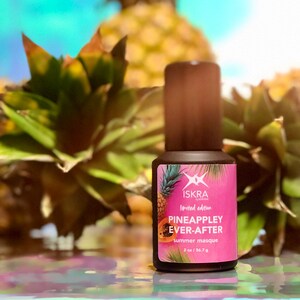 May include: A small brown bottle with a pink and white label. The label says "Iskra Limited Edition Pineapple Ever-After Summer Masque 2 oz / 56.7 g".