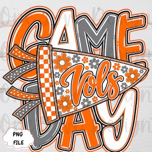 Puede incluir: Un diseño gráfico con el texto GAME DAY en letras negritas de color naranja, blanco y gris. Un banderín triangular con borde a cuadros naranja y blanco, patrones de flores naranjas y grises, y el texto en cursiva Vols sobre las letras.