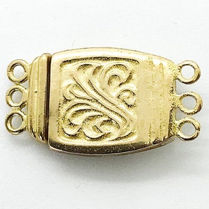 May include: Gold-toned metal clasp with a decorative floral design and three loops. The clasp is designed to connect two strands of jewelry.