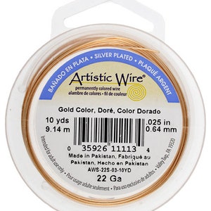May include: A spool of gold-colored Artistic Wire, 22 gauge, silver-plated, 10 yards (9.14 meters) long. The label reads "Gold Color, Doré, Color Dorado" and includes a barcode and the text "Made in Pakistan".