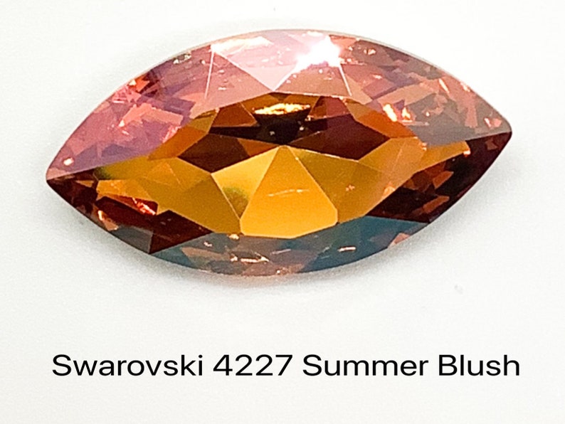Peut inclure: Gros plan sur un cristal Swarovski en forme de larme de couleur Summer Blush. Le cristal est facett&eacute; et pr&eacute;sente une teinte chaude orange-rouge.