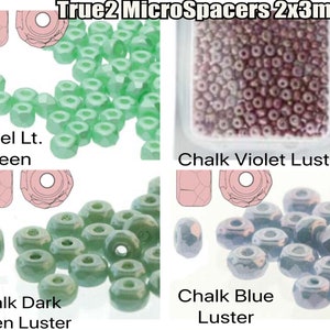 Op de afbeelding: Assortiment van 2x3 mm glazen kralen in verschillende kleuren, waaronder pastel lichtgroen, krijtviolet glans, krijt donkergroen glans en krijtblauw glans. True2 MicroSpacers 2x3mm.