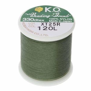 May include: A spool of K.O. Beading Thread in a muted green color. The label reads "100% NYLON" and "Made in Japan." The spool has the text "330dtex" and "XT25R 120L" printed on it. The thread is tightly wound.
