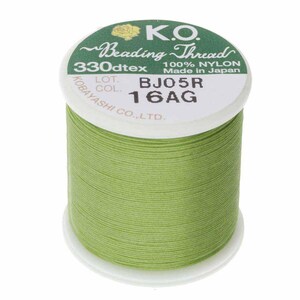 May include: A light green spool of K.O. Beading Thread. The label displays "330dtex 100% NYLON Made in Japan". The spool is white with green text and a floral design.