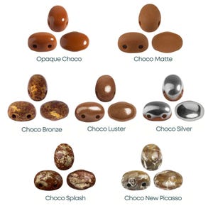 Puede incluir: Una colección de cuentas ovaladas en varios tonos de marrón y plata. Las cuentas están etiquetadas con nombres como "Opaque Choco", "Choco Matte" y "Choco Silver". Las cuentas tienen dos agujeros para ensartar y son adecuadas para la fabricación de joyas.