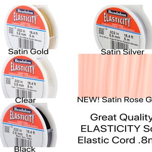 May include: Four spools of Beadalon ELASTICITY elastic cord in satin gold, satin silver, clear, and black. Each spool is labeled with the cord's size: 0.8 mm (0.032 in) and length: 5 m (16.4 ft). The text "Great Quality ELASTICITY Soft Elastic Cord .8mm" is displayed below the spools.