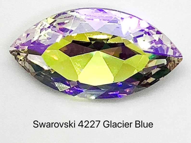 Peut inclure: Un cristal clair, facett&eacute;, de forme marquise avec une finition arc-en-ciel iris&eacute;e. Le cristal est &eacute;tiquet&eacute; "Swarovski 4227 Glacier Blue".