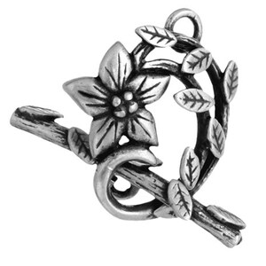 Könnte beinhalten: Silberfarbener Metallanhänger mit einer stilisierten Blume mit Blättern und einem Zweig. Der Anhänger hat eine Öse oben zum Anbringen an Schmuck oder andere Bastelarbeiten.