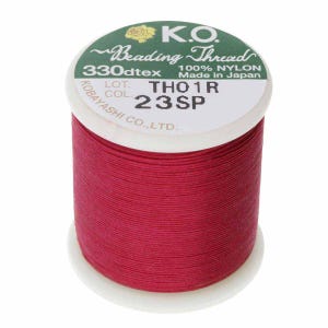 Pode incluir: Um carretel de fio vermelho para miçangas. O rótulo diz "K.O. Beading Thread 330dtex 100% NYLON Made in Japan." O carretel está rotulado "THO1R 23SP" e é da Kobayashi Co., LTD. O fio é de uma cor vermelha vibrante e sólida.
