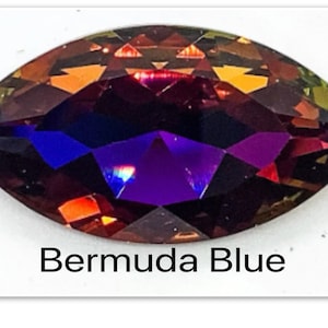 Peut inclure: Gros plan sur une pierre pr&eacute;cieuse facet&eacute;e et iris&eacute;e de forme marquise. La pierre pr&eacute;cieuse a une teinte violette fonc&eacute;e avec des nuances de rouge et d'orange. Le texte "Bermuda Blue" est &eacute;crit sous la pierre pr&eacute;cieuse.