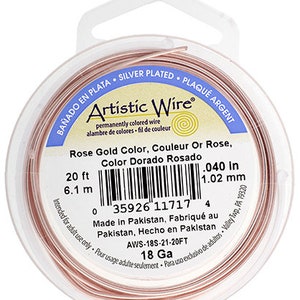 May include: A spool of 20 feet (6.1 metres) of 18 gauge rose gold coloured wire. The wire is silver plated and is 0.040 inches (1.02 mm) thick. The label reads "Artistic Wire" and includes the UPC code 35926 11717.