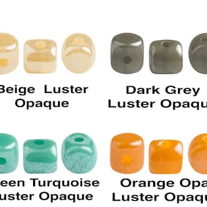 May include: Four sets of three square beads in different colors and finishes. The beads are beige with a luster finish, dark gray with a luster finish, green turquoise with a luster finish, and orange with an opal finish.