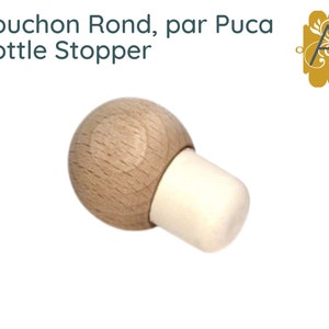 May include: A wooden bottle stopper with a round top and a white cork. The stopper is made of natural wood and has a simple, elegant design.