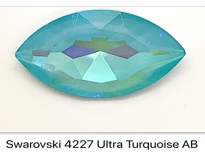 Peut inclure: Un cristal Swarovski bleu turquoise avec une finition iris&eacute;e. Le cristal est en forme de marquise et a une extr&eacute;mit&eacute; pointue.